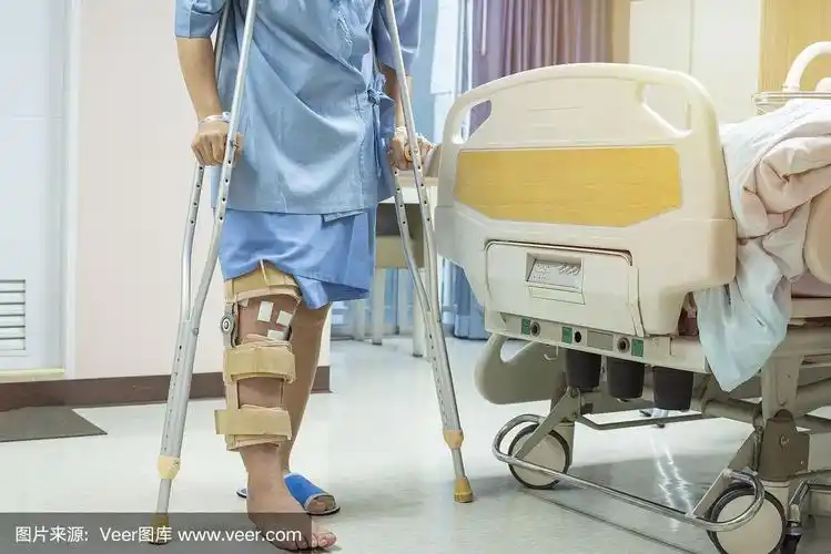 病房内拄拐站立的患者,行后十字韧带手术后,用膝关节支架支撑,亚洲拄