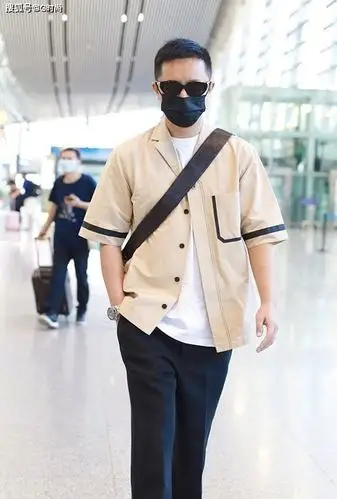 韩庚身着卡其色衬衫搭配巧克力色斜挎包 走路带风