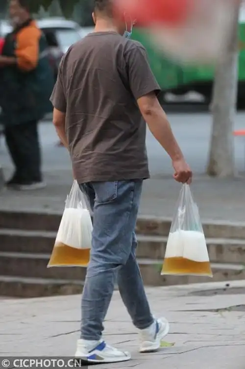 2020年6月6日,山东省青岛市一位市民用塑料袋拎着刚买到的啤酒.