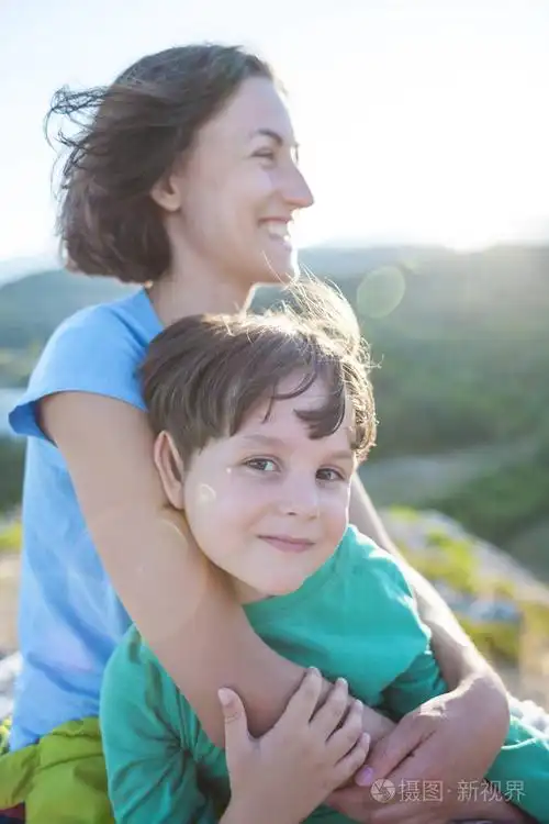 妈妈拥抱她的儿子.女人在大自然里花时间和孩子在一起.