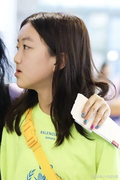 王菲小女儿现身机场星范儿足,大秀美腿玩手机专注,喜爱奢侈品