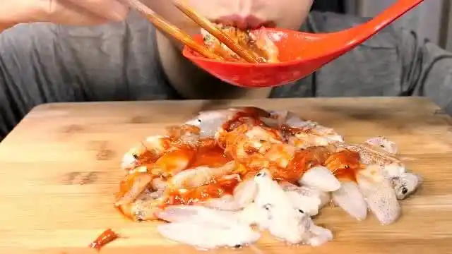 国外小哥生吃小鱿鱼,淋上辣酱一口几个真的不腥吗?