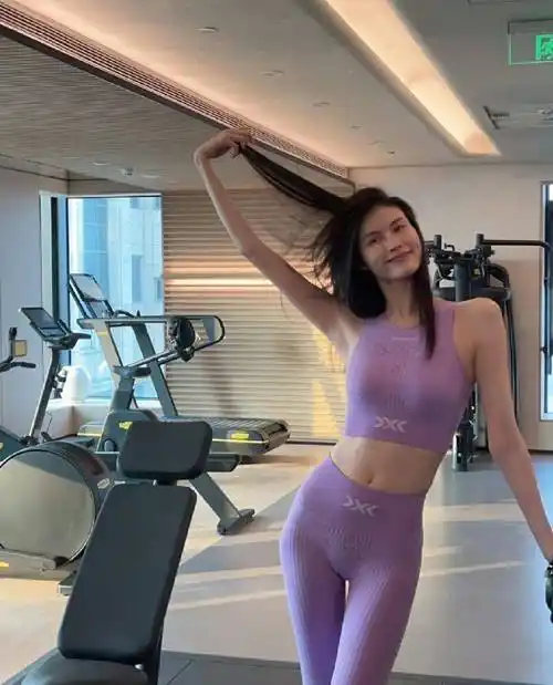 这是何穗穿着亮粉色瑜伽运动服的照片.她应该去健身房做瑜伽.