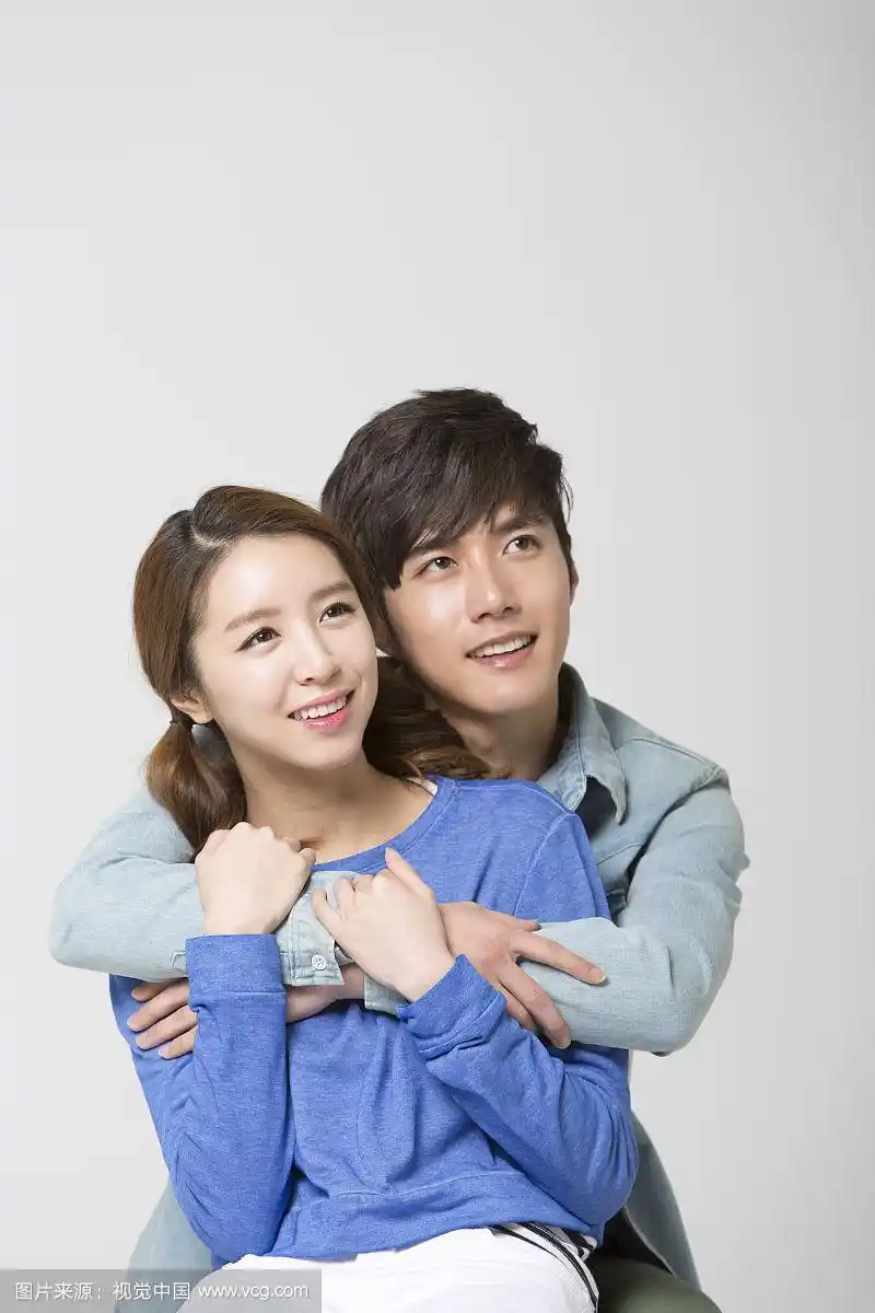 一对穿着休闲装的夫妇,男人从背后拥抱着女人