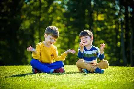 裤的人类婴儿的腿坐在公园的草地上的小女孩小孩坐在绿色的草地上母亲