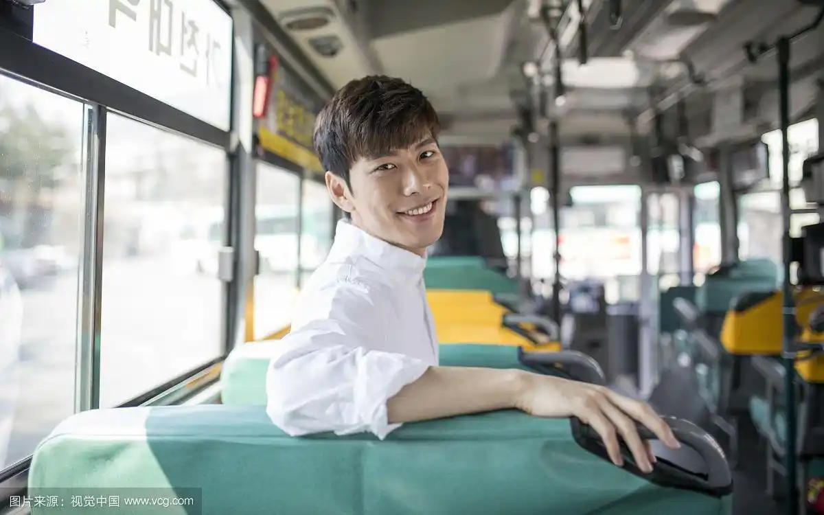 微笑的男人在公共汽车上回头看