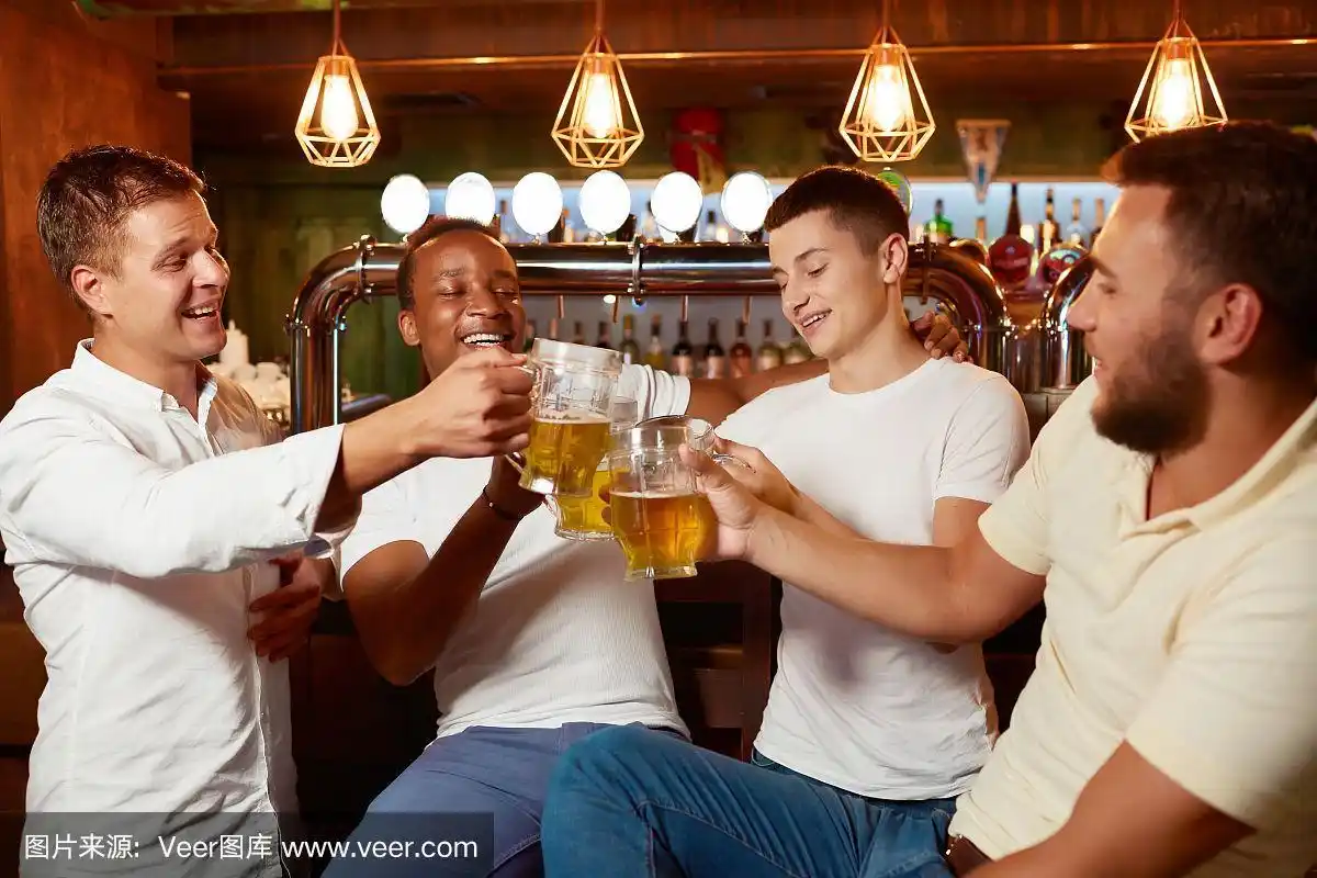 四个帅哥一起在酒吧喝啤酒碰杯.