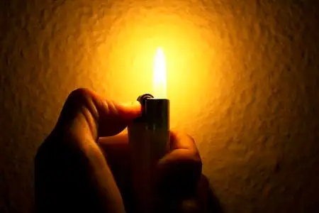 手与打火机点燃火花照片