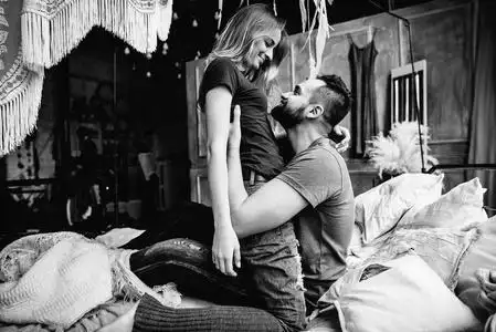 亲爱的夫妇在大卧室的床上互相拥抱. 爱情故事侧视黑白照片照片