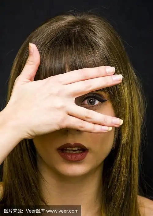 美女用她的手遮住她的一只眼睛