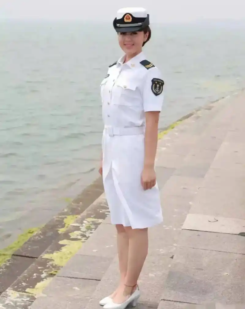 这位女兵站在海边,一身白色海军服打扮的她,在海风吹拂下英气逼人,又