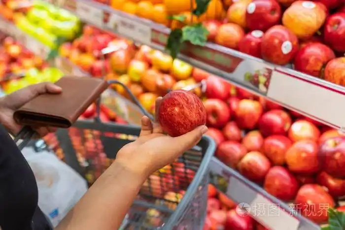 在水果店买新鲜苹果的年轻女人