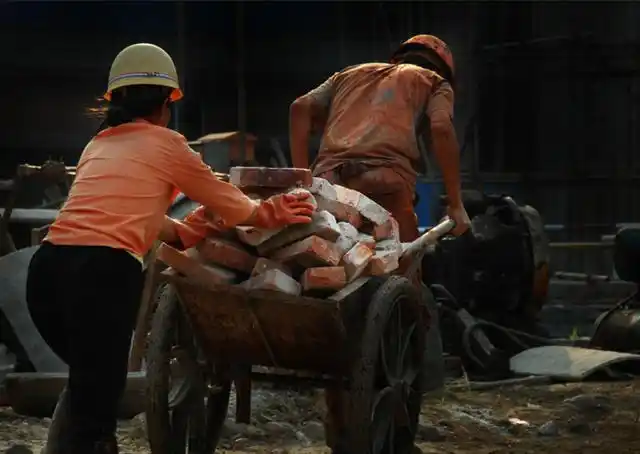 图为:在工地里搬砖的农民工夫妻,他们来自甘肃,家有父母和两个孩子.