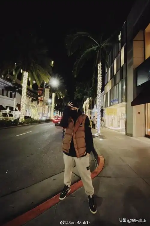 照片中的pgone上身穿一件黑色卫衣,内搭一件棕色马