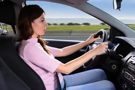 坐汽车旅行的年轻女子的侧视图照片