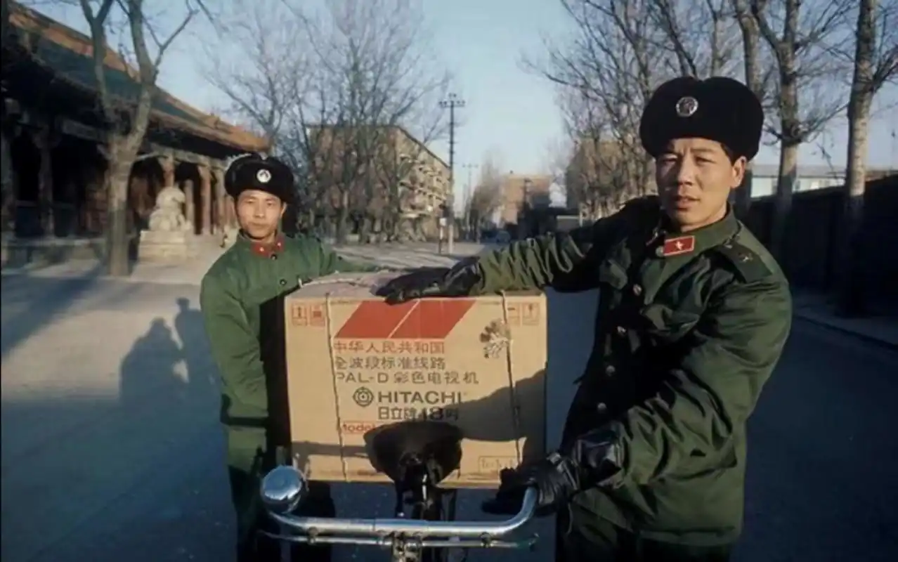 八十年代,北京老照片,两名穿着六五式军装的解放军战士,用自行车驮着