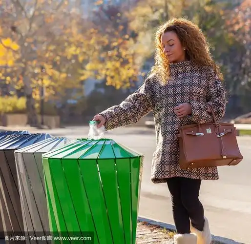 女人在街上把垃圾扔进垃圾桶