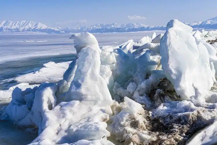 大面积冰面被风刮到湖岸,在岸边筑起一道冰墙.