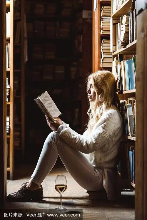 侧面的金发女人看书和坐在图书馆的地板上