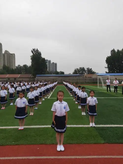 一1班的小可爱们身穿校服,站姿笔挺,安安静静地等待家长入场佩戴