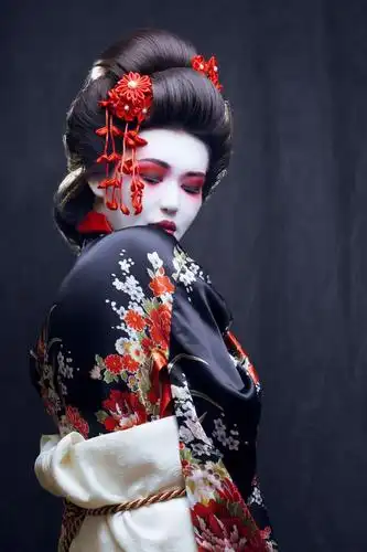 和服中的年轻艺妓在黑色背景下投掷樱花