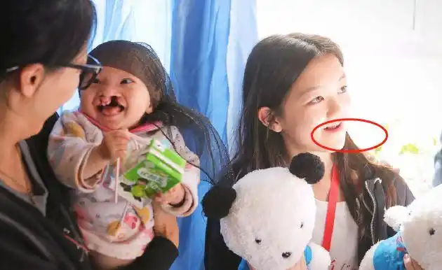 从照片中可以看到,李嫣穿着一件黑色外套,手里拿着两个毛绒玩具,虽然