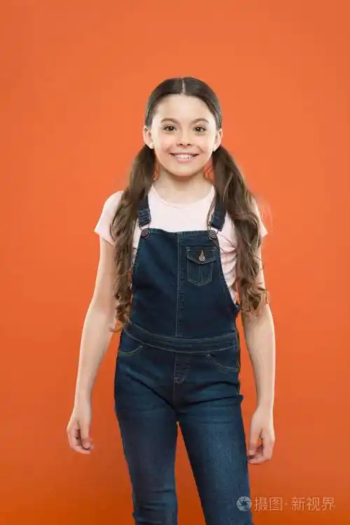 橙色背景下的快乐孩子.小孩笑得很漂亮.