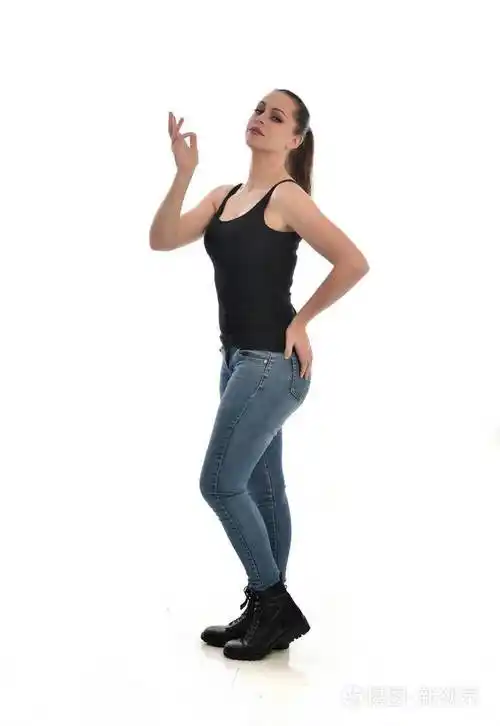 穿黑色单身牛仔裤的黑发女孩的全长肖像站立姿势侧轮廓孤立在白色工作