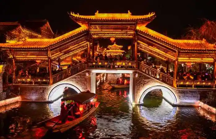 游客在山东台儿庄古城乘坐摇橹船观赏古运河风光.