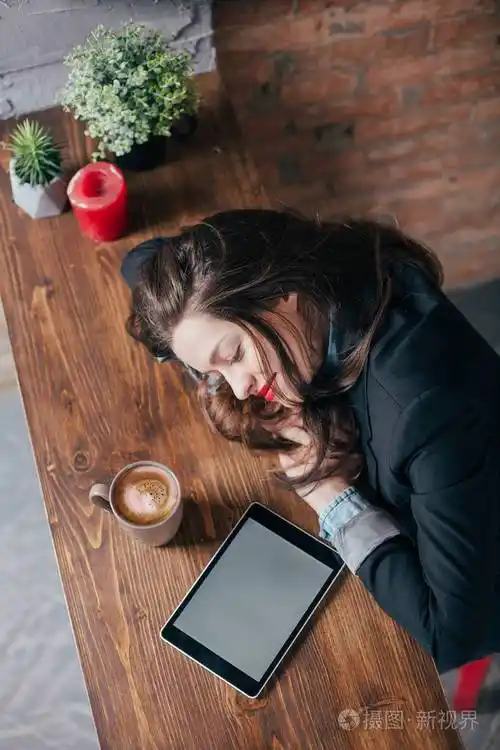 年轻的自由职业者女孩在阁楼内部的笔记本电脑上努力工作