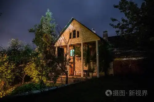 夜晚用月亮在森林中建造的山景或夜晚用云彩和星星建造的老式乡村房子