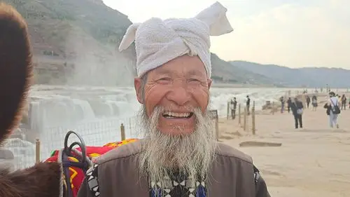 牵毛驴73岁张国宝老人白羊肚毛巾缠头,叼着一只旱烟袋,摆