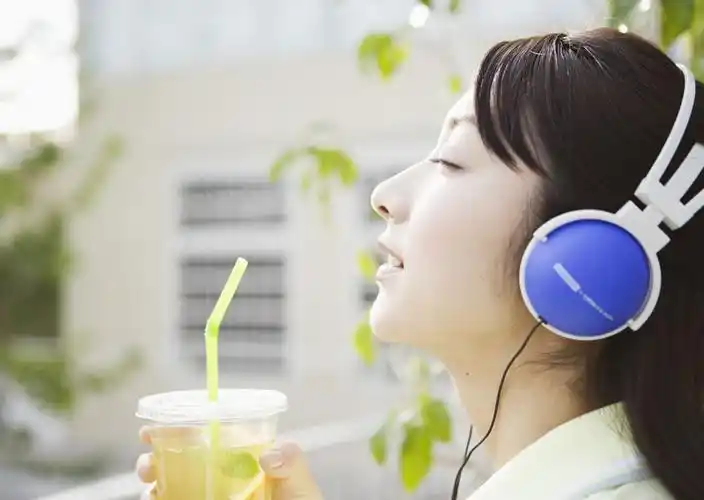 享受阳光,音乐和饮料,听音乐的图片