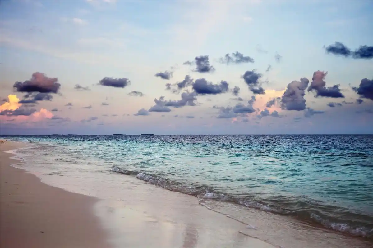 海岸美景净收眼底:蓝天白云,阳光明媚,浅蓝色的海水