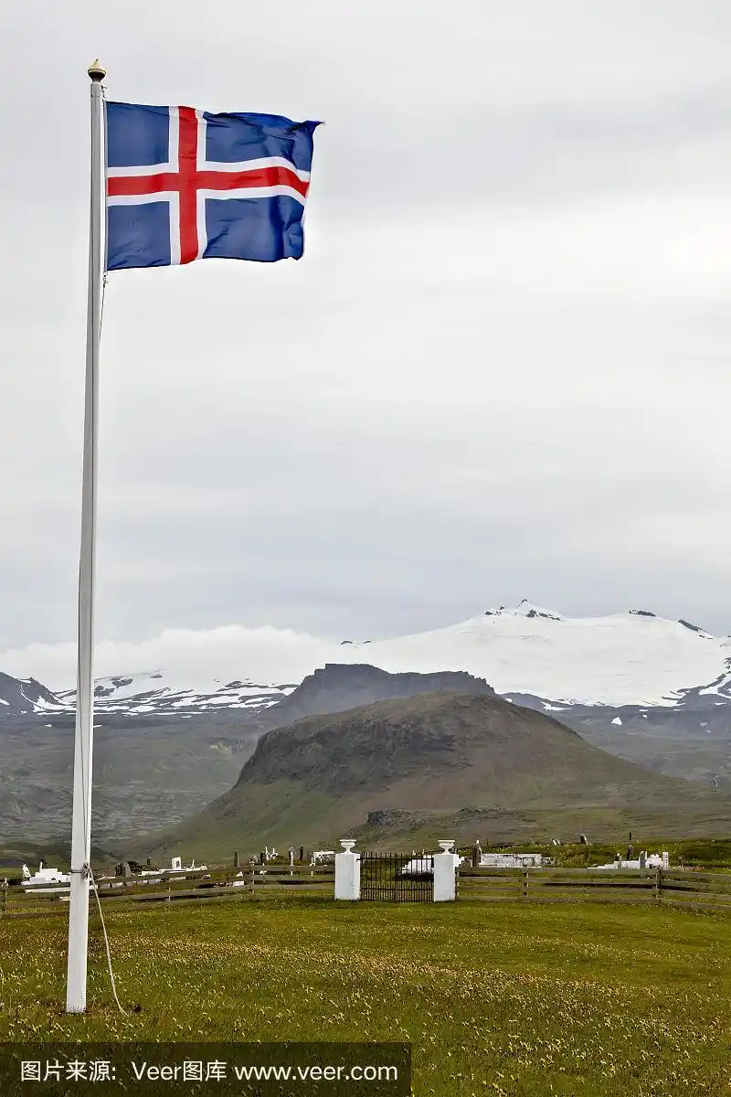 在一个以雪山为背景的墓地旁挂着冰岛国旗