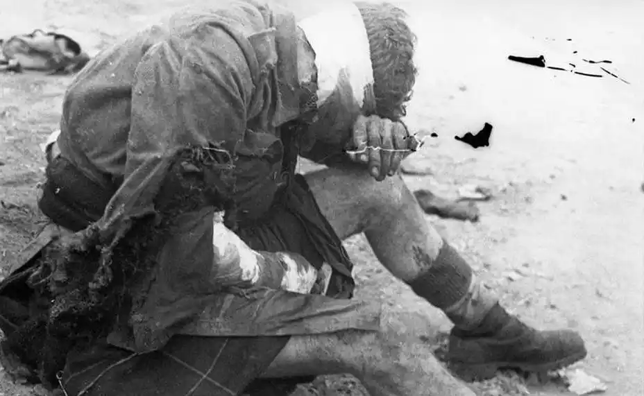 英德两军3月28日交战之后,一名德国士兵在检视战场,地上躺着英军士兵