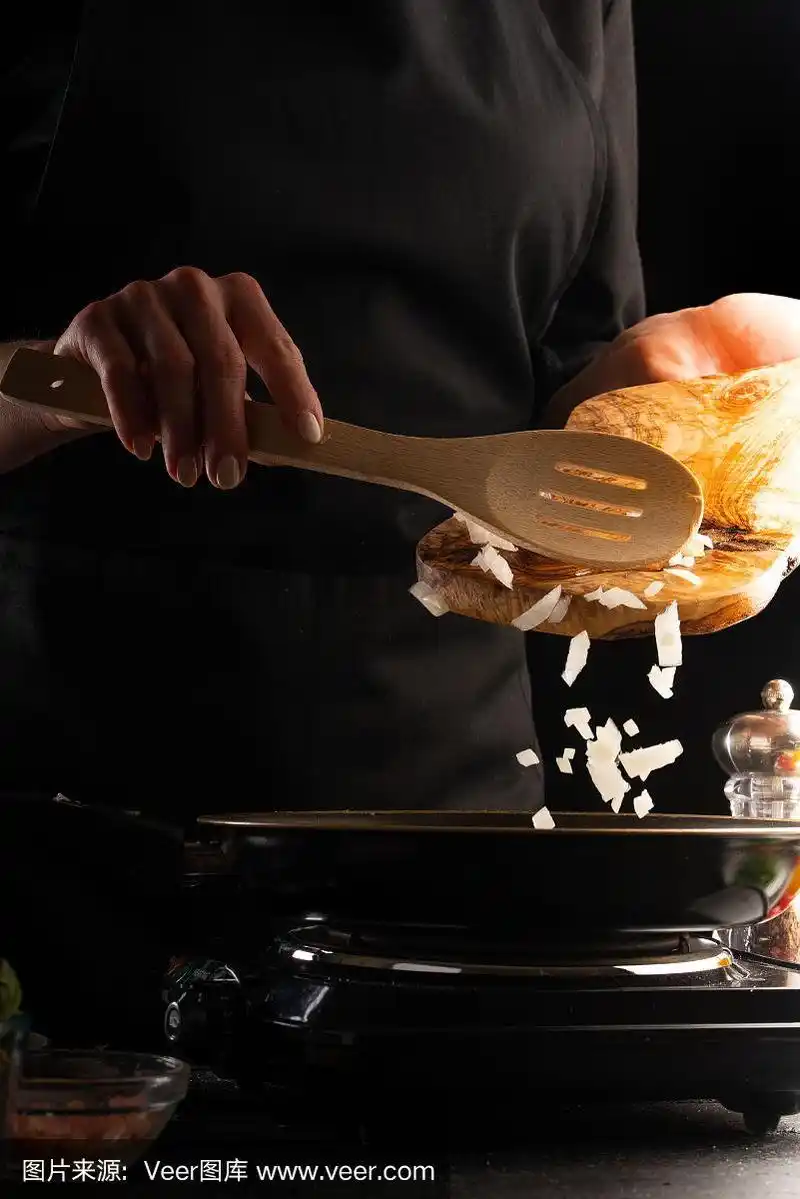 厨师做菜,用平底锅煎洋葱.以蔬菜为背景,在运动中冻结.美食和烹饪.
