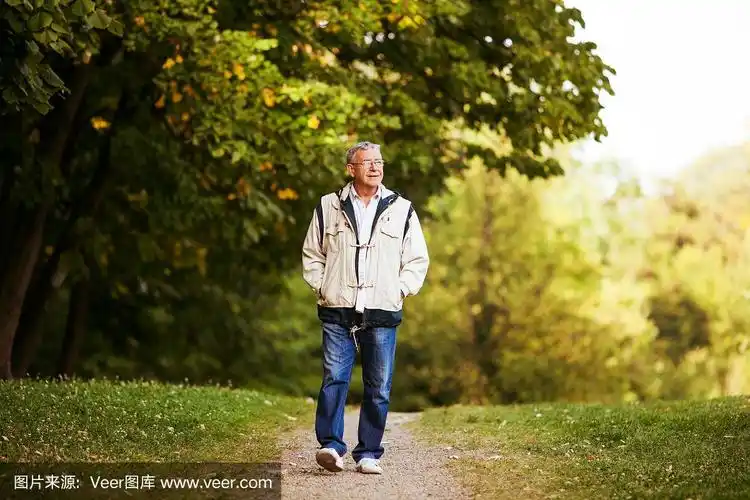 一位穿着夹克的老人在公园里散步