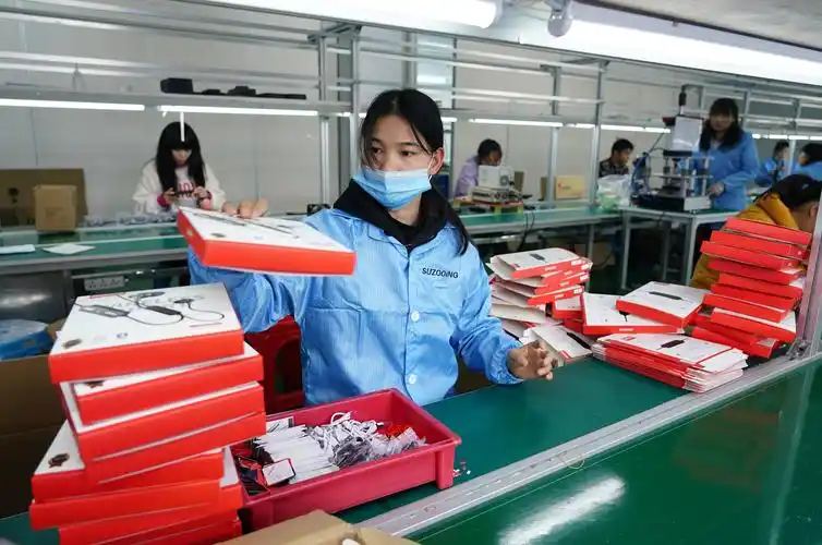 3月15日,在安康市高新区一家电子终端产品企业车间内,工人在包装电子