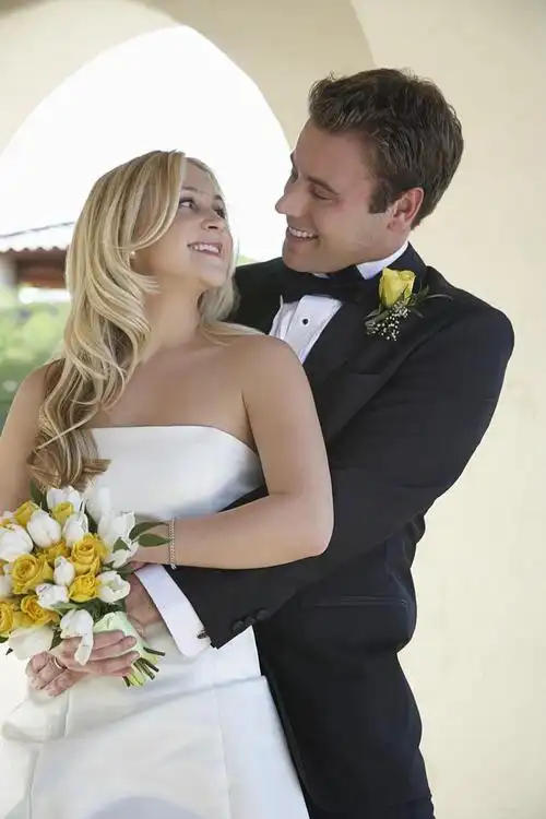 新郎抱新娘,ウィンドウで掛かっている美しいブライダル ドレス