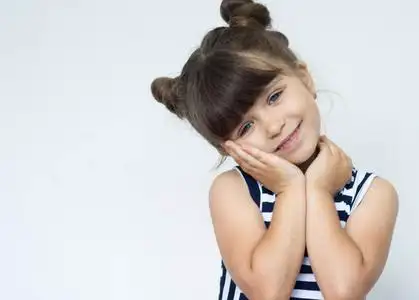 微笑愉快的可爱的孩子保持手在下巴之下.复制空间照片