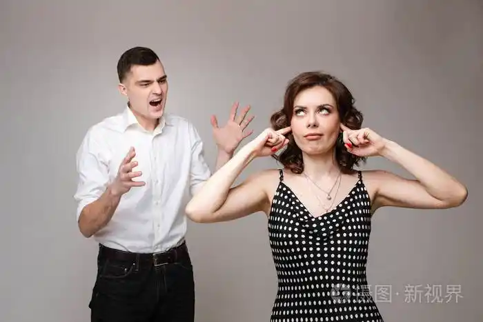 一对热恋中的愤怒的情侣站在一起大声尖叫照片被隔离在灰色的背景上