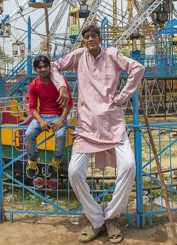 无奈之下,他只能到游乐园工作,装扮巨人和游客合影,不过每天只能赚到