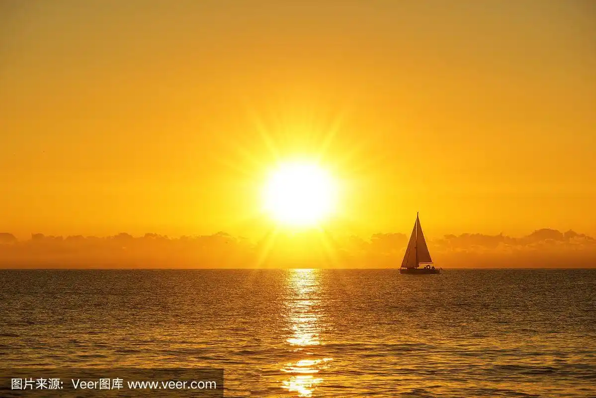 随着日出的太阳航行的帆船