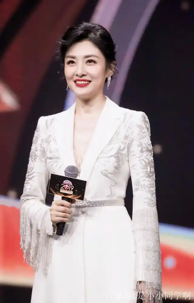 她是中央电视台主持人董卿齐肩,穿着一身白色绣花西服亮相
