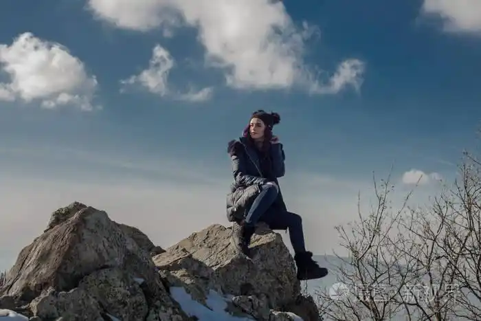 在悬崖上摆姿势的年轻美女