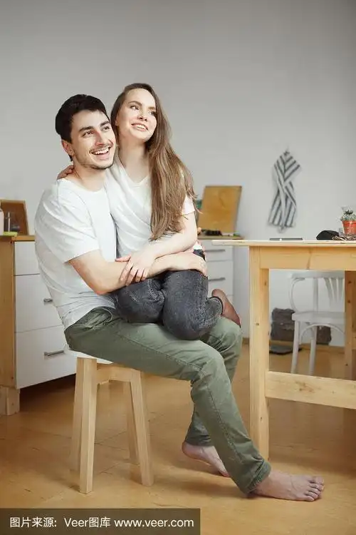 一个女人坐在她男朋友的腿上.