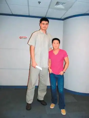 黎明和姚明合影,姚明尽管显得很自然,无所谓身高差距,但是在姚明们鞍