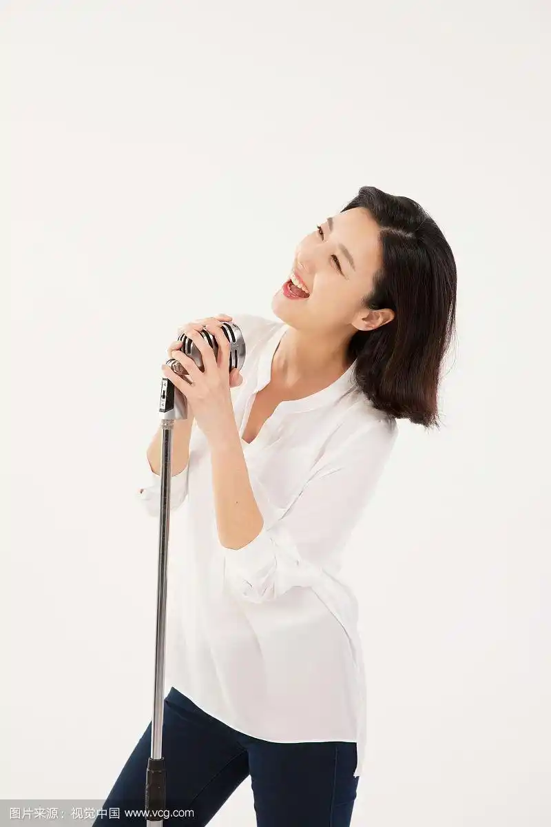 30多岁的女商人拿着麦克风唱歌