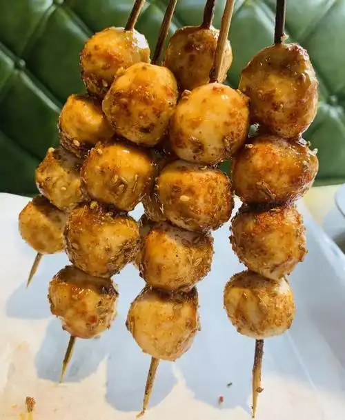 烤鱼丸是另一种风味格外q弹爽嫩四个大鱼丸串成一串香味儿入鼻2暖黄色